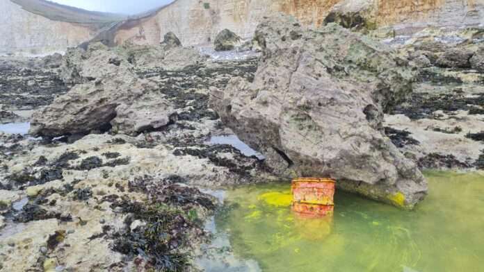 A member of the public raised the alarm on Saturday after spotting a container in the sea at Hope Gap near Seaford, which was leaking an unidentified yellow substance.