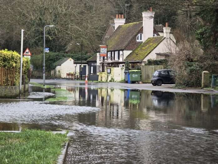 Despite improvements, the threat of re-flooding keeps Denton Road shut, impacting local life and businesses.