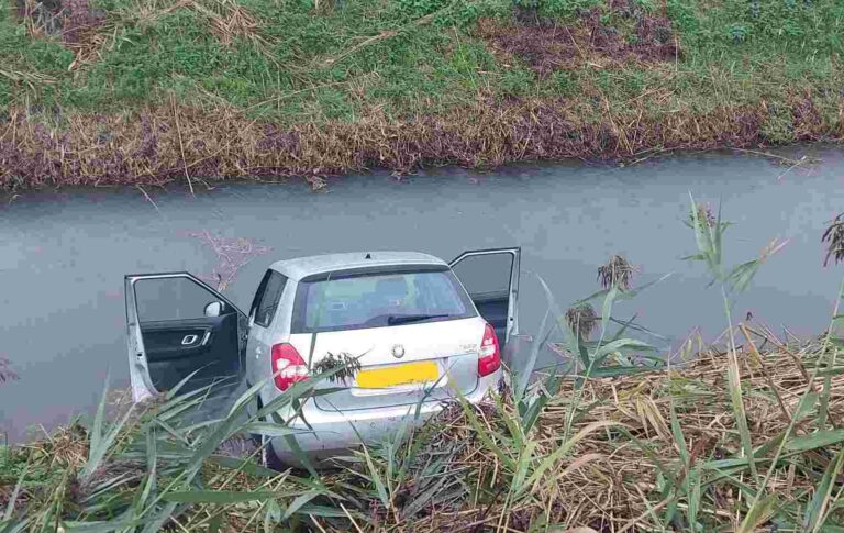 Car takes a dip after collision on grass verge in Rye