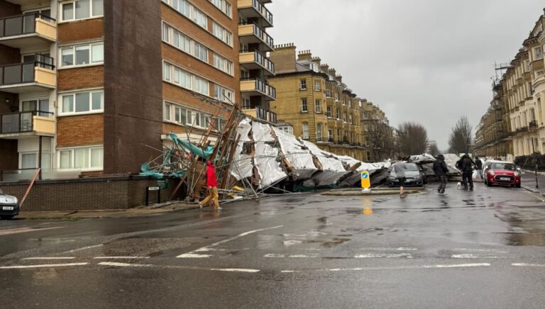 Scaffolding has collapsed from a seafront building in Hove, crushing parked cars but causing no injuries.